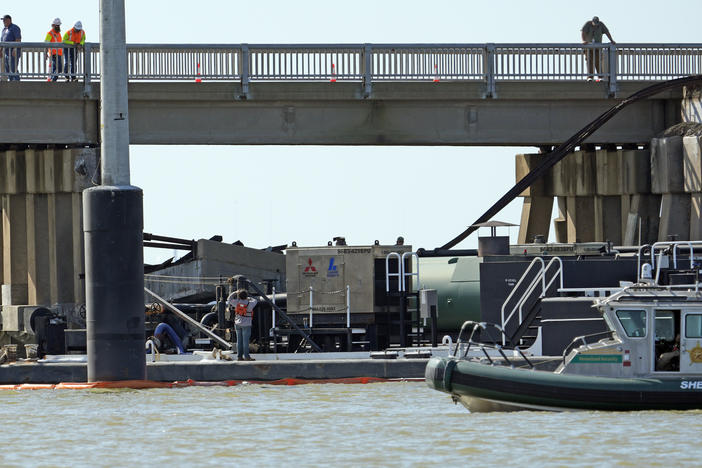 Workers survey the site where a barge crashed into the Pelican Island Bridge, on Wednesday in Galveston, Texas.