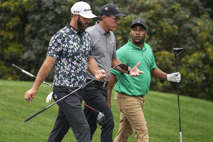 Dustin Johnson, Phil Mickelson, and Harold Varner III, walks in the 11th fairway during a practice for the Masters golf tournament at Augusta National Golf Club, Tuesday, April 4, 2023, in Augusta, Ga. 
