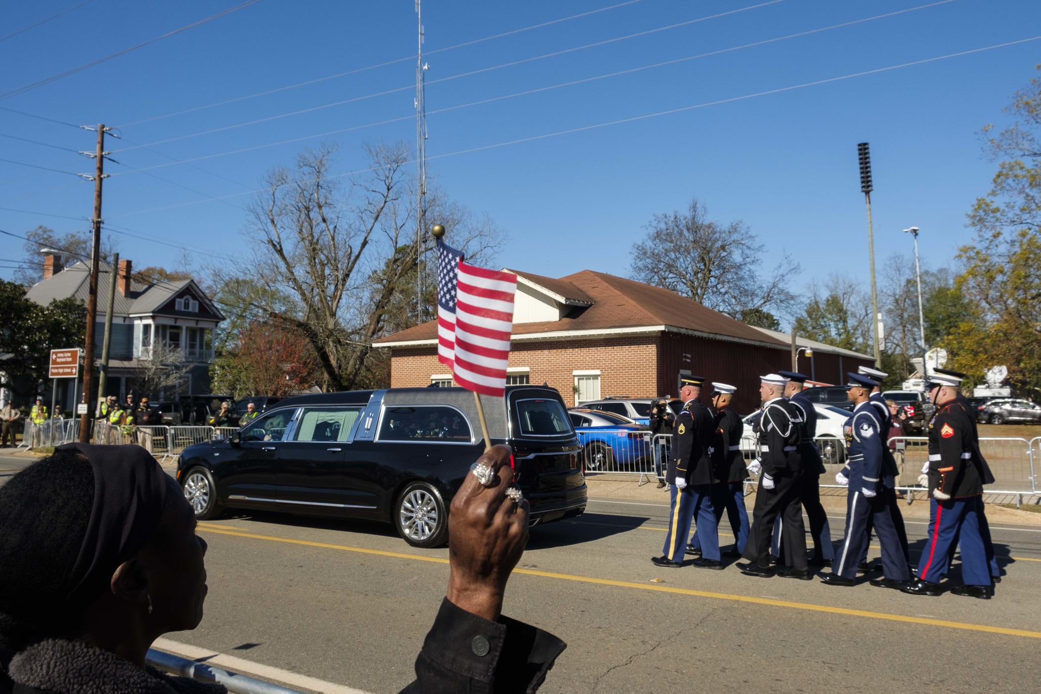 After the funeral for Rosalynn Carter at Maranatha Baptist Church, the hearse carrying her to the Carter family home proceeded through her hometown of Plains where locals lined the street. 