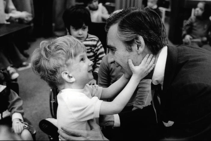 Fred Rogers and a young child.