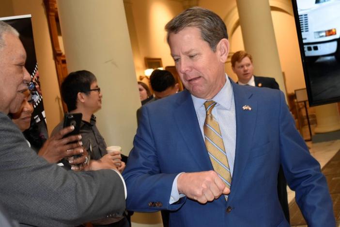 Kemp bumps elbow with man at the State Capitol