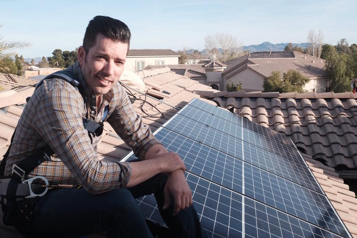 "Power Trip" director Jonathan Scott takes a break from installing solar panels on a rooftop.