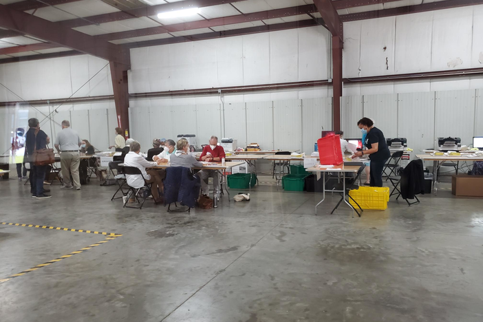 Ballots are counted at a series of tables in a large room in Chatham county.