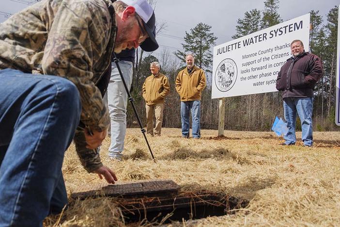 From left, Monroe County Commissioner John Ambrose, Commission Chair Greg Tapley and Monroe County resident Charles Grizzard watch as a worker turns on the water service to Grizzard’s house Tuesday. Grizzard was the first resident to get city water in a project inspired by worries about coal ash at Georgia Power’s Plant Scherer.