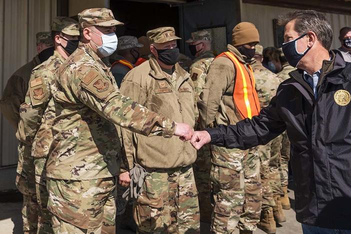 Governor Brian Kemp greets Georgia Air National Guard members staffing the mass vaccination site at the state farmers market in Macon. 