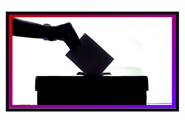 An illustration of a hand dropping a ballot into a ballot box.