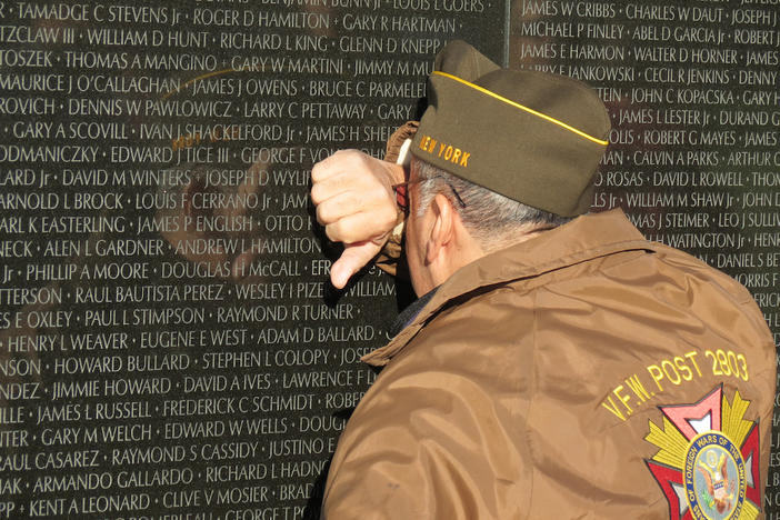 A man in a VFW jacket mourning.