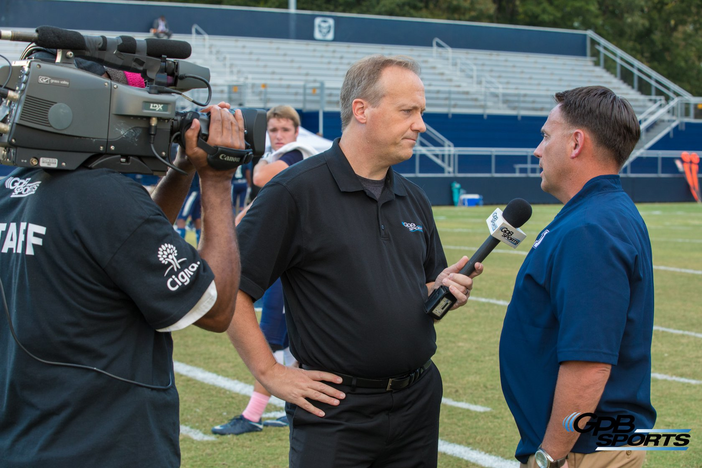 Jon Nelson interviews a coach on the sidelines