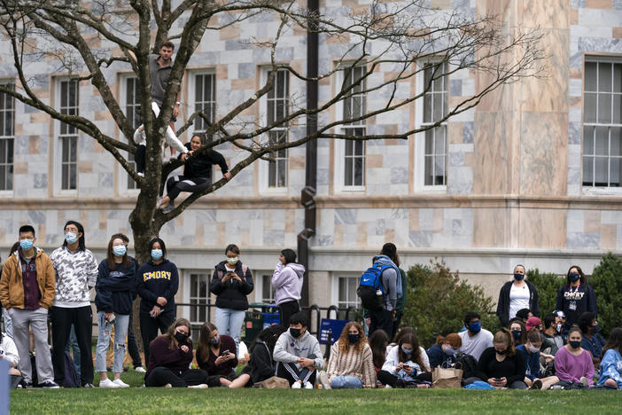 Students and other bystanders gather in the Quad as President Joe Biden and Vice President Kamala Harris hold an event in a nearby building at Emory University, Friday, March 19, 2021, in Atlanta.