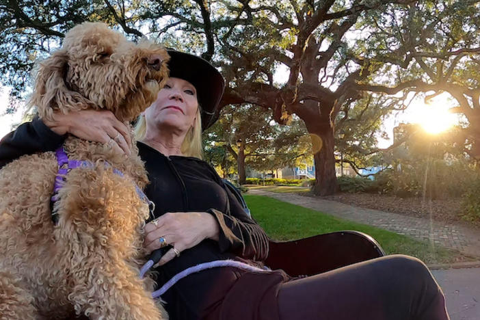Sharon Collins and her dog Jessi on a park bench.