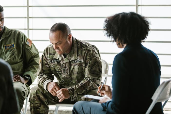 photo of a soldier looking down in a group meeting
