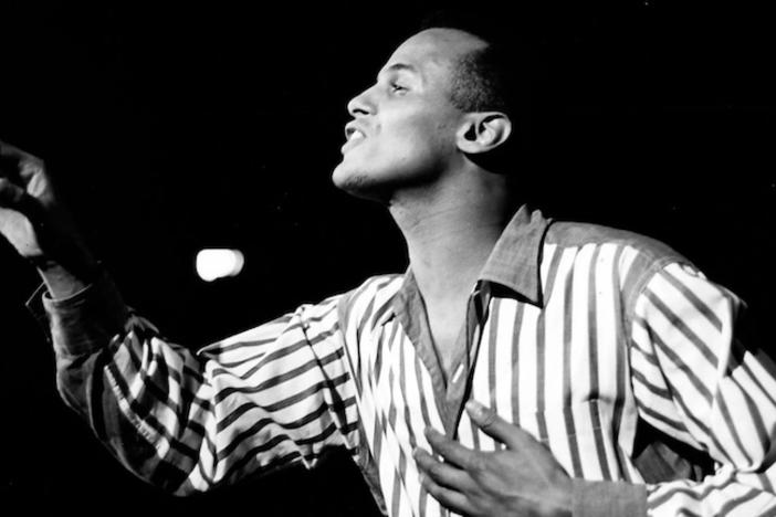 Harry Belafonte singing in a black and white picture.