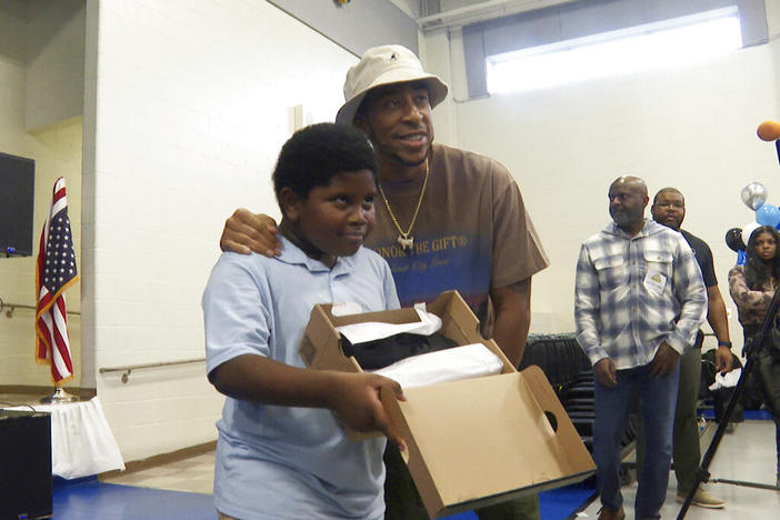 Rapper and actor Ludacris, right, smiles with a student who received new shoes at Miles Intermediate Elementary School in Atlanta on Wednesday, Dec. 7, 2022.
