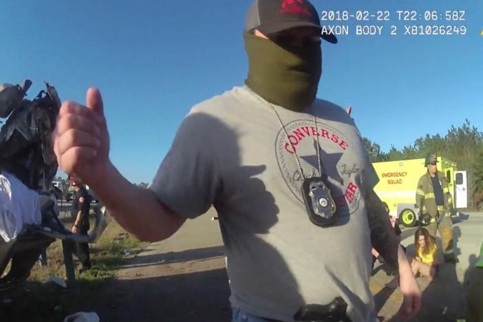  A masked Glynn County narcotics unit officer at the scene of a February 2018 crash, where GBNET officers allegedly sought to cover up their involvement. Credit: Body camera screenshot