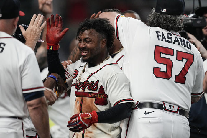 Atlanta Braves' Ozzie Albies, center, celebrates after hitting a winning three-run home run in the 10th inning of a baseball game against the New York Mets, Thursday, June 8, 2023, in Atlanta.