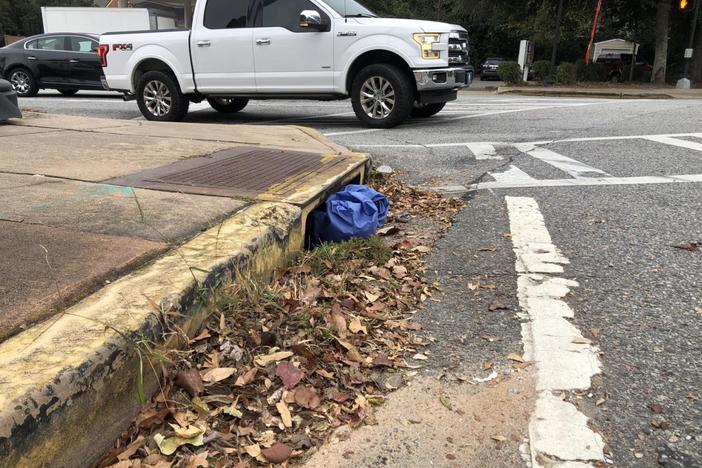 A discarded pair of medical scrubs blocks the storm drain near the intersection of College and Forsyth streets. (Liz Fabian)