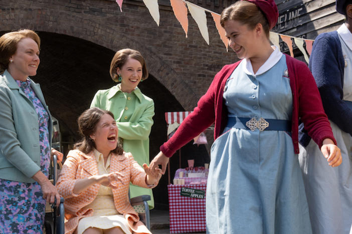 An image from Call the Midwife with a midwife and 3 women at a party outdoors.