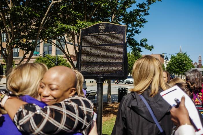 A new historical marker on Macon's Poplar Street describes the slave market on the site of the brick building in the left background of the image which at one time recently was a yoga studio. 