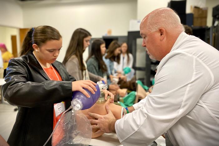 Ninth-grader Katie Bolton of Screven County simulates bag-valve-mask ventilation on a medical mannequin at Mercer University School of Medicine's Savannah campus, as instructor Joe Slattery guides her through the technique.