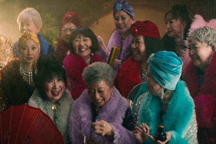 A group of smiling elderly ladies in fancy dress