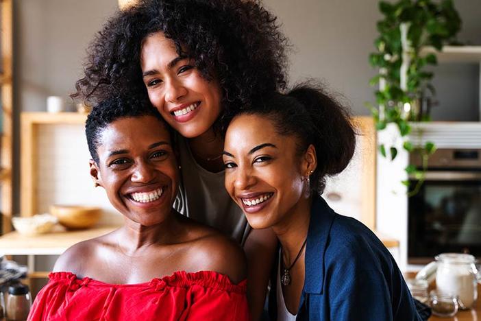 Three Black women smiling