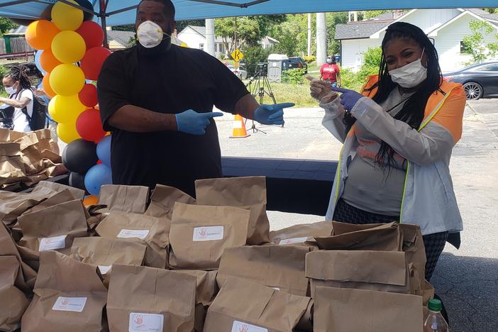 Michael "Killer Mike" Render hands out meals with PAWkids founder Latonya Gates at Bankhead Seafood Market.