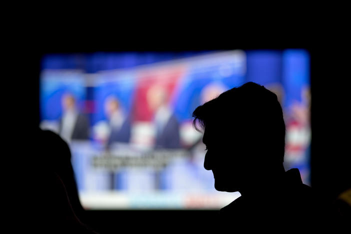A person watches a broadcast of a Democratic presidential debate at a bar in Atlanta, Thursday, June 27, 2019.