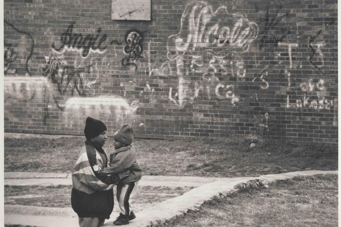 A man and child next to a wall full of graffiti in the East Lake area of Atlanta, 1996. The documentary "East Lake Meadows: A Public Housing Story" airs on PBS on Tuesday, Mar. 24 at 8 p.m.