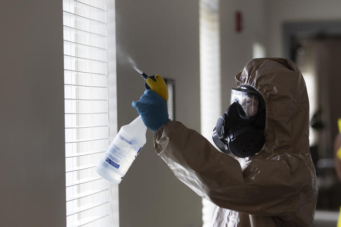 A member of the Georgia National Guard works to clean and disinfect hallways and common areas at Provident Village assisted living and memory care home, Tuesday, May 5, 2020, in Smyrna, Ga. There have been no cases among residents or staff there.
