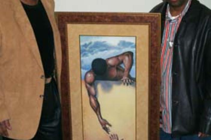 Artist Gilbert Young pictured with actor, film director Spike Lee and "He Ain't Heavy" painting.