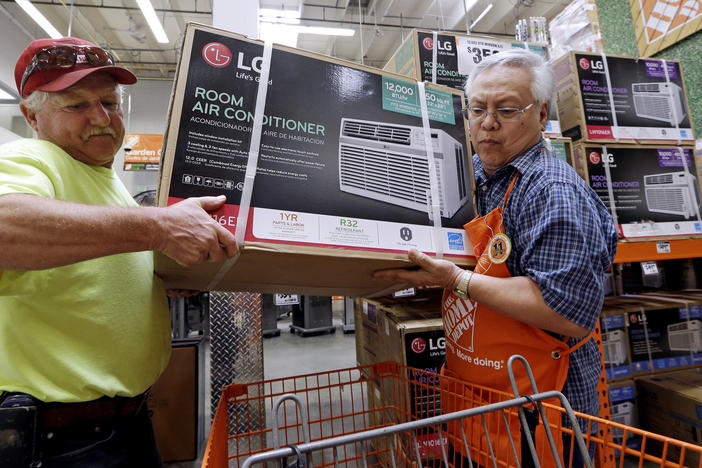 Home Depot store greeter Danny Olivar, right, helps a customer buying an air conditioner. A new study finds Georgians will need to adapt to more days of extreme heat in the coming decades.
