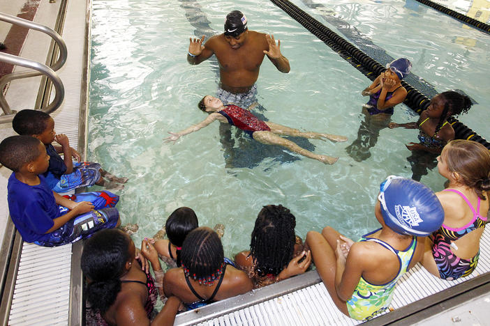 USA Swimming, Olympic Gold Medalist Cullen Jones, center, gives area children a swimming lesson at Centenary College in Shreveport La.