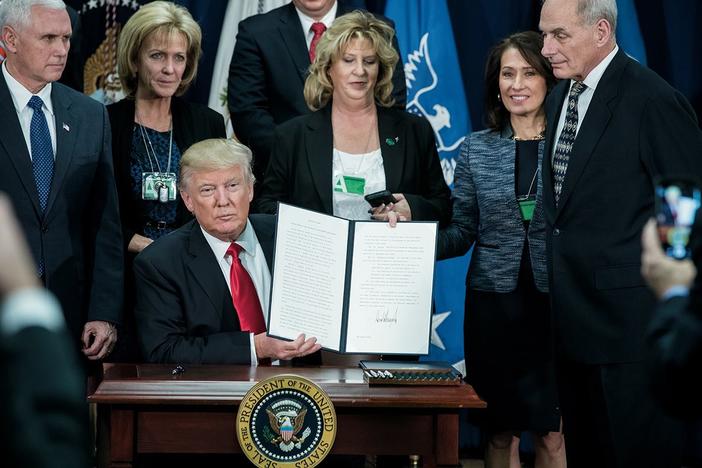 President Donald Trump displays a signed Executive Order at the Department of Homeland Security in Washington, D.C., Wednesday, Jan. 25, 2017. 