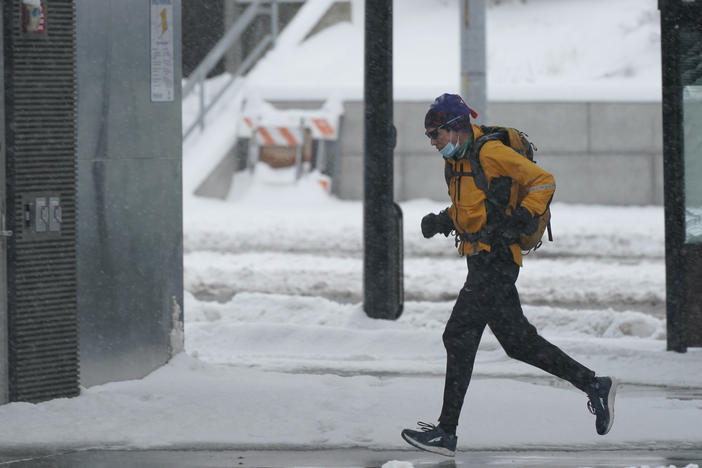 A person runs in the snow on Saturday on the University of Washington campus in Seattle. Winter weather was expected to continue through the weekend in the region. Winter conditions are forecast to extend through much of the U.S. early into the week.