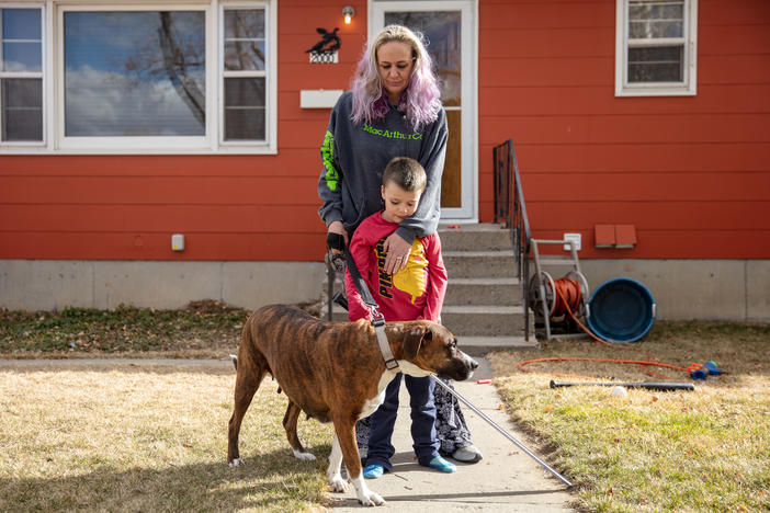 Barbara Gaught stands outside the home she's now renting in Billings, Mont., with her 5-year-old son, Blazen, and their dog, Arie. Gaught and her family were evicted from the mobile home they had owned outright and lived in for 16 years because they fell behind on 'lot rent' for the little plot of land under the mobile home.
