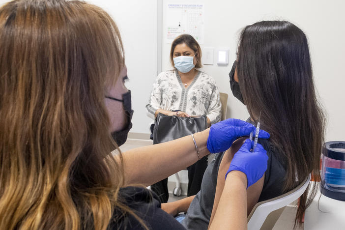 A 16-year-old gets a Pfizer-BioNTech COVID-19 vaccine in Anaheim, Calif., on April 28. Advisers to the Centers for Disease Control and Prevention now say it's not necessary for adolescents to wait two weeks after a COVID shot to receive routine immunizations.
