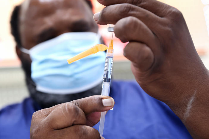 A COVID-19 vaccine dose is prepared at a pharmacy in Baton Rouge, La., on Aug. 17. About 14 million people received their first dose of a COVID-19 vaccine in August.