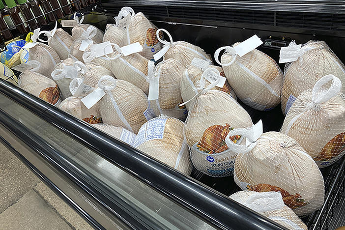 Frozen turkeys sit in a refrigerated case inside a grocery store in southeast Denver. The Farm Bureau says high demand for meat and supply chain woes have increased the cost of Thanksgiving dinner this year.