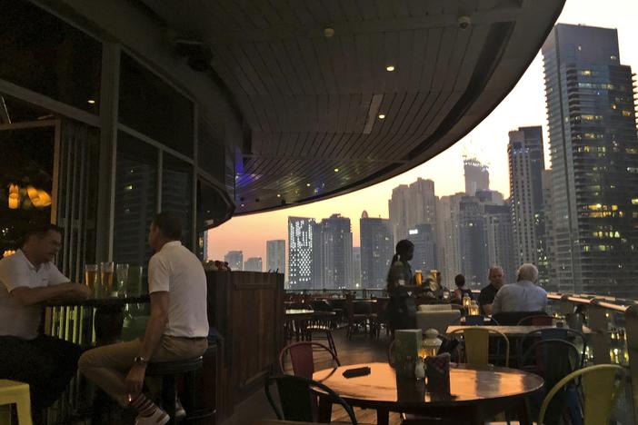 People enjoy drinks at a restaurant overlooking the Marina district in Dubai, United Arab Emirates, in 2019. The country is loosening its liquor laws and other restrictions.