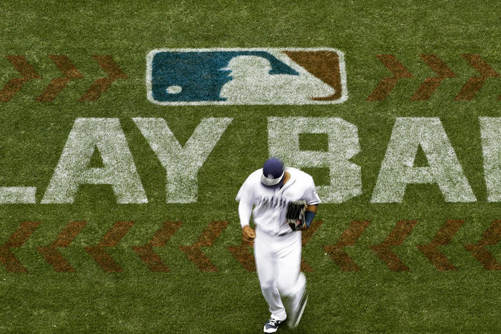 San Diego Padres left fielder Allen Cordoba passes a logo for Play Ball, an initiative from Major League Baseball and USA Baseball, during the fifth inning of a baseball game against the Colorado Rockies in 2017 in San Diego. Players voted Thursday to accept MLB's offer on new labor deal, paving way to end 99-day lockout and salvage 162-game season.