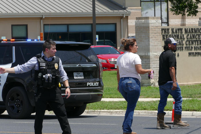 A law enforcement officer helps people cross the street at Uvalde Memorial Hospital after a shooting was reported earlier in the day at Robb Elementary School, Tuesday, May 24, 2022, in Uvalde, Texas.