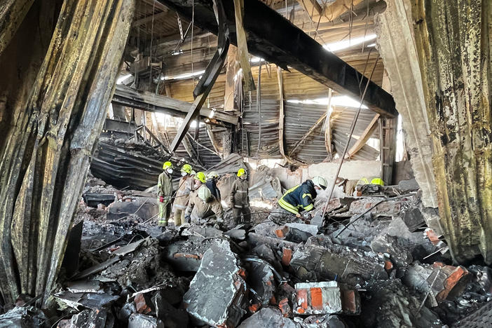 Workers clean up wreckage at the Amstor Mall in Kremenchuk, Ukraine, after the building was hit by a Russian cruise missile.