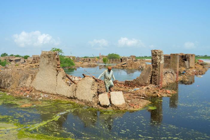 A man walks over his collapsed mud house after heavy monsoon rains in Jaffarabad district, Balochistan province, on Aug. 28.