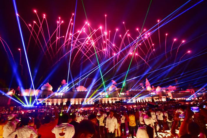 People watch a laser show on the banks of the river Sarayu during Deepotsav celebrations on the eve of the Hindu festival of Diwali in Ayodhya on November 3, 2021.