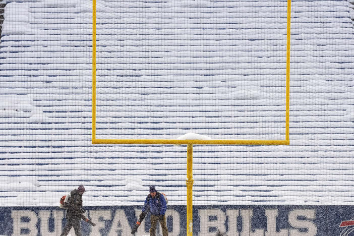 Grounds crew work to clear snow off the field at Highmark Stadium before an NFL football game between the Buffalo Bills and the Miami Dolphins in Orchard Park, N.Y., Saturday, Dec. 17, 2022.
