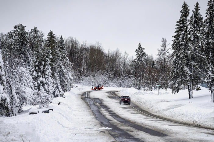 A car slowly travels down a road after a second round of snow passed through northern Minnesota Thursday, Dec. 15, 2022, in Duluth, Minn.