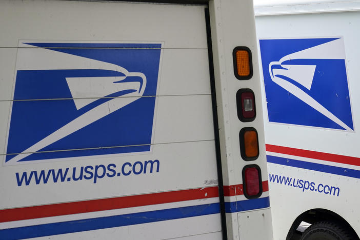 Mail delivery vehicles are parked outside a post office in Boys Town, Neb., on Aug. 18, 2020. The Postal Service said Tuesday it will sharply increase the number of electric-powered delivery trucks in its fleet and will go all-electric for new purchases starting in 2026.