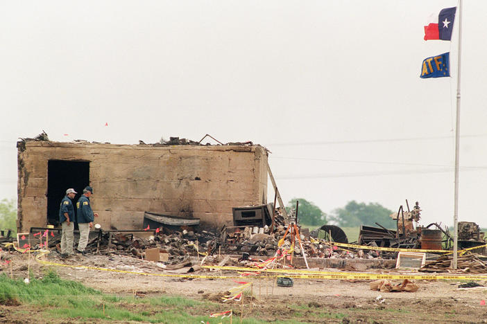 The Texas and the ATF flags fly at half staff April 23, 1993, over the only structure left standing after a fire destroyed the the Branch Davidian compound in Waco, Texas on April 19.