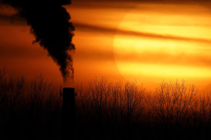 Emissions from a coal-fired power plant are silhouetted against the setting sun in Kansas City, Mo., on Feb. 1, 2021. The Environmental Protection Agency is tightening rules that limit emissions of mercury and other harmful pollutants from coal-fired power plants, updating standards imposed more than a decade ago.