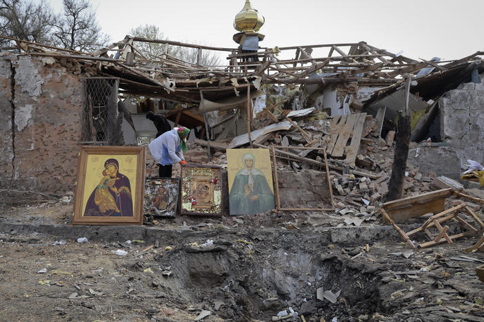People save icons as they clear rubble after a Russian rocket ruined an Orthodox church in an Easter attack, in Komyshuvakha, in Ukraine's Zaporizhzhia region, early hours Sunday.